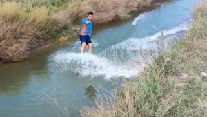 Traktör ile köydeki sulama kanalında sörf yaptı